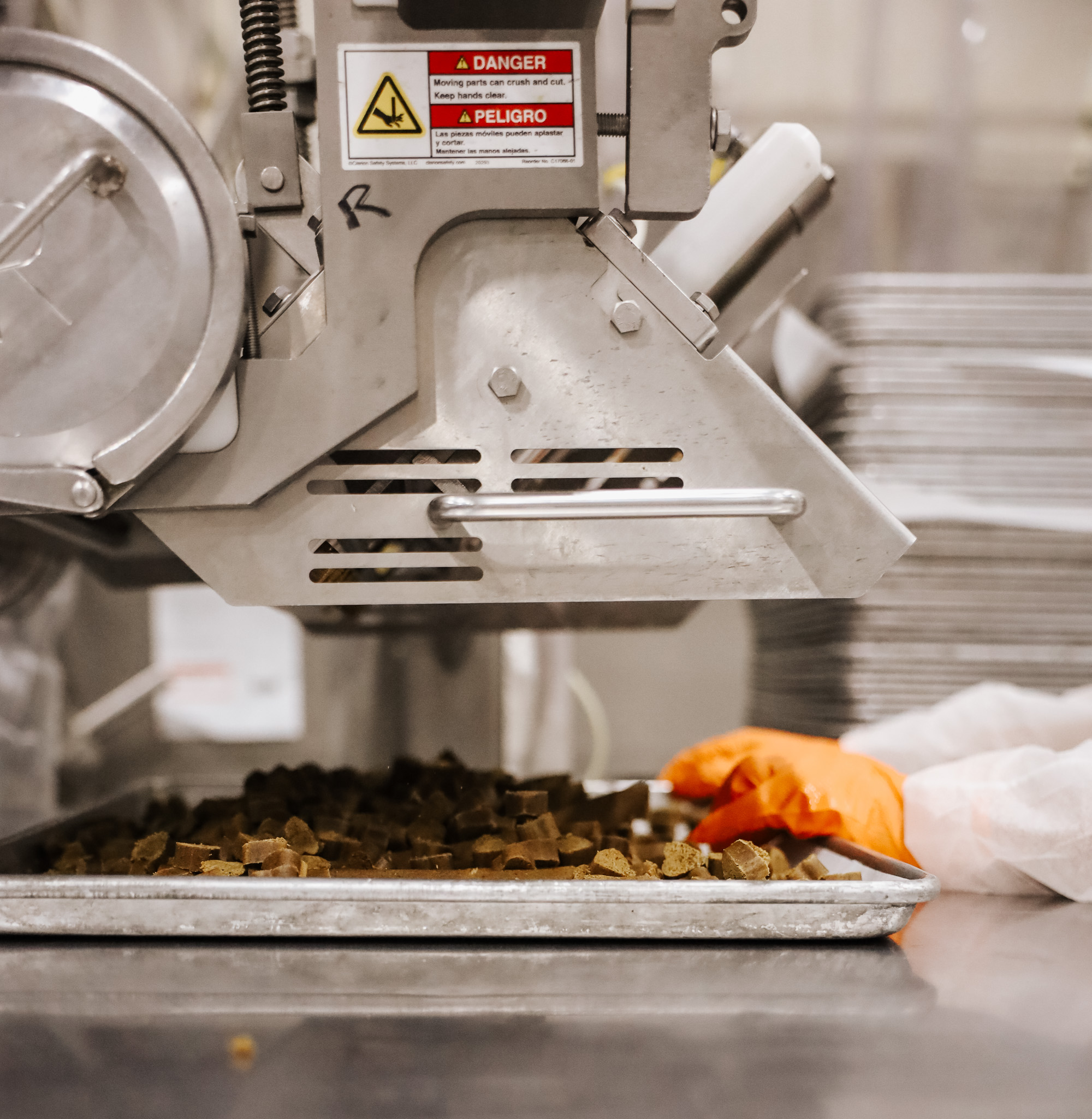 Close up of the machinery pouring canine supplements into the pans